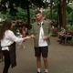 screenshot of a recruiter handing out a card to a passerby